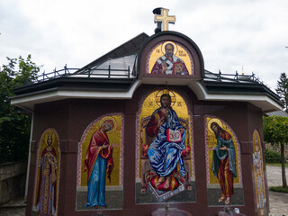 Fototapeta premium Faucet with icons of saints in yard of monastery Ozren dedicated to Saint Nicholas, serbian orthodox temple in village Kaludjerica, Petrovac municipality on mountain Ozren, Bosnia and Herzegovina