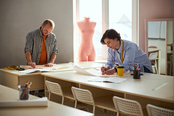 Drawing process in a classroom performed by two tailors