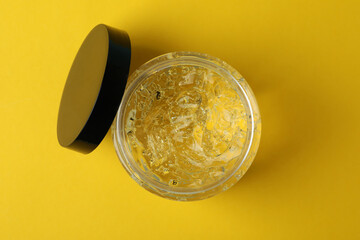 Jar of styling gel on yellow background
