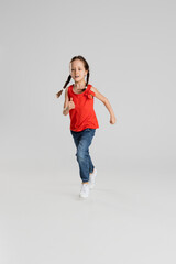 Happy kid, girl isolated on white studio background. Looks happy, cheerful, sincere. Copyspace. Childhood, education, emotions concept