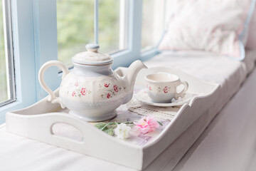 Fototapeta na wymiar Morning tea near a window. Tea pot and a cup. Tender beautiful blue decor