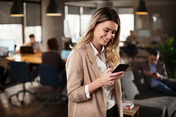 Businesswoman in office. Smiling businesswoman using the phone in office.