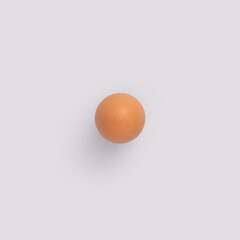Simple Easter concept with single raw egg on grey background