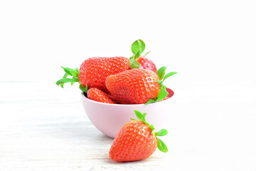 Strawberries in a bowl, presented on a white background