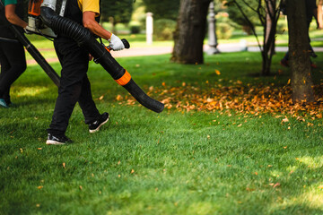 A woman operating a heavy duty leaf blower.