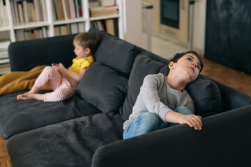 bothers using smartphone, sitting quarreled on sofa and