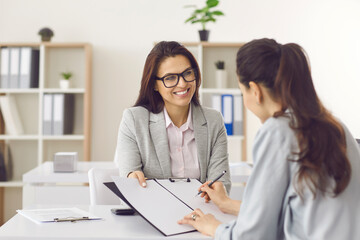Contract signing, last formality. Smiling bank manager or recruiter hold financial document. Female client putting signature or job applicant being hired on vacant place signing employment agreement