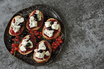 Plate with cheese and jam sandwiches. Toast with currant jam and garganzola cheese. Keto.