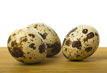 Quail eggs on a wooden table close-up.