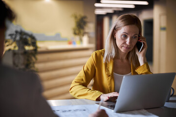 Busy blonde female looking at screen of her laptop