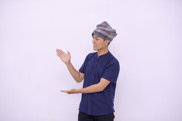 Young man Asian muslim over isolated white wall extending hands to the side for inviting to come