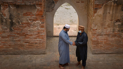 Fototapeta na wymiar Two Muslim men approached and greeted in an old mosque in Ayutthaya, Thailand.
