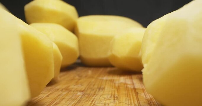 detailed extreme close-up of peeled potatoes on wooden board.