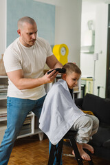 father cutting hair to his son at home