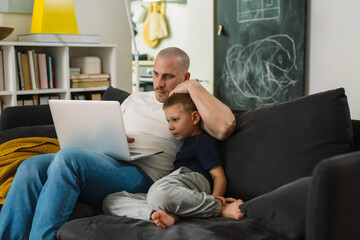 father and son using laptop computer