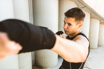 Man exercising and fighting in outside, boxer in gloves. male boxer portrait