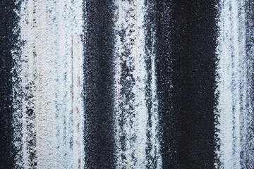 Fragment of an asphalt road covered with snow strips after passing cars. View from above