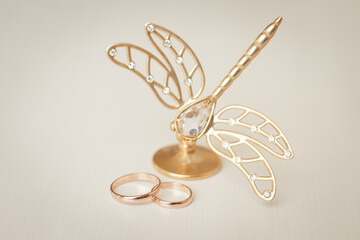 Wedding rings and statuette of golden butterfly, wedding accessories