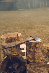 The axe lying on log. Chopping wood. Countryside living. Dry grass.