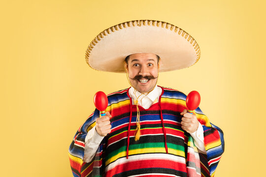 Happy man in sombrero and bright poncho isolated over yellow background  foto de Stock | Adobe Stock