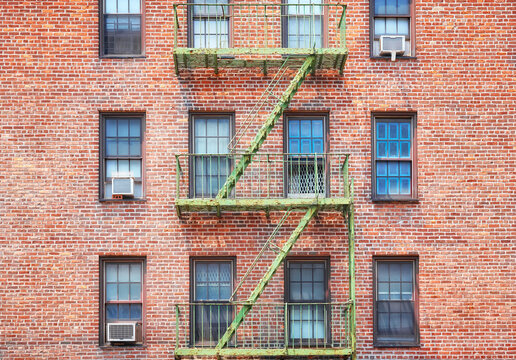 Old brick building with green fire escape, New York City, USA.