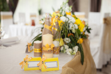 Decoration of wedding table. Yellow and beige colors. Wedding champagne, candles, flowers