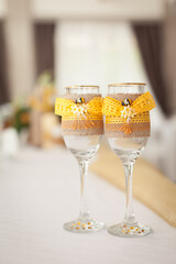 two glasses with yellow ribbon and a little bee