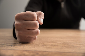 man fists on a wooden table