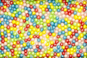 Background from multicolored shiny candy. Bright sweets round beads for your design