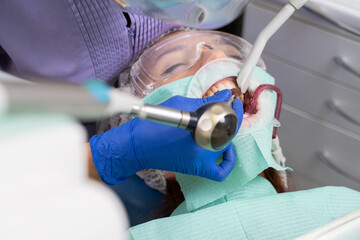 Close-up of a dentist's hand with a special instrument at the time of powder cleaning of the patient's oral cavity. focus on the doctor's hand.