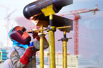 Worker Welding process on metal steel pipe and spark light in factory wearing equipment protective...