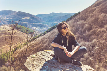 Naklejka premium Young Woman Sitting above the Mountain with Stunning View .Pirin Mountain ,Bulgaria 