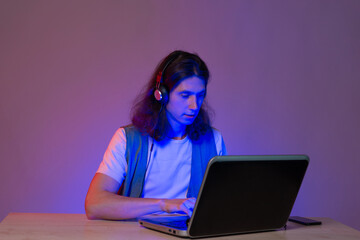 Student or gamer at a laptop, portrait in neon tinting.