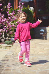 Fototapeta premium Portrait of Happy Smiling Child Girl Running Outdoor 