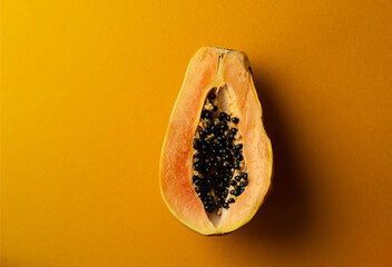 Sliced fresh and tasty papaya and green lime on a yellow background. Tropical fruit. Copy space.