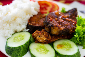 Com Tam - a close-up of Vietnamese cuisine: delicious broken rice with fried fish, cucumbers, salad. Delicious food - lunch.