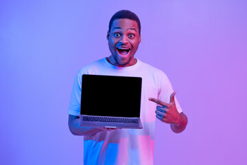Check This. Overjoyed Black Guy Pointing At Laptop Computer With Blank Screen