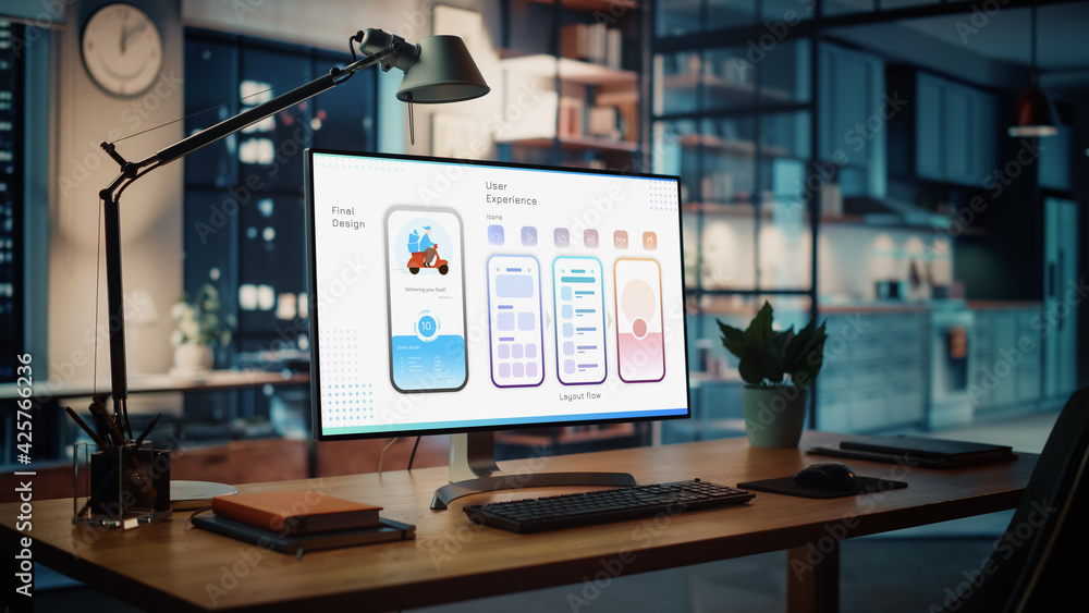 Poster Shot of a Desktop Computer with Food App User Interface Developing Software Standing on the Wooden Desk in the Creative Cozy Living Room. In the Background Warm Evening Lighting and Open Space Studio.