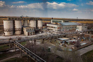 Fototapeta na wymiar Outdated Soviet mining and processing plant. Concrete storage elevator.