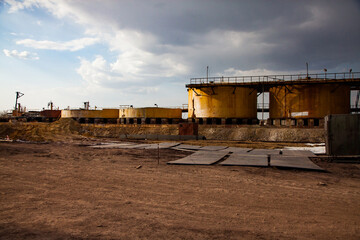 Fototapeta premium Demolition of outdated Soviet sulfuric acid plant.Old rusted yellow steel storage tanks for acid.