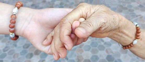 Young hand holding old hand women, Concept for the elderly care.