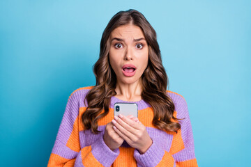 Portrait of impressed person hold phone open mouth staring camera wear pullover isolated on blue color background