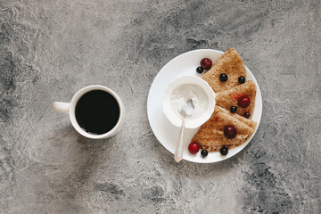 pancakes with fresh berries for breakfast and black coffee