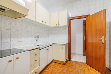 Bright empty kitchen with tiled floor and walls before renovation. Old typical apartment in Barcelona for rent or sale
