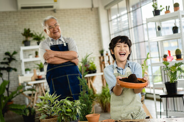 Grandfather gardening and teaching grandson take care  plant indoors