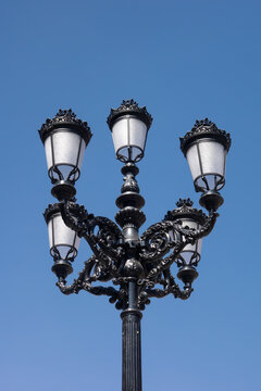 Vintage street light post against the blue sky. Old street lamp