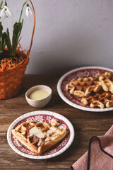 Homemade Belgian Waffles served with condensed milk on wooden background. Breakfast. Selective focus