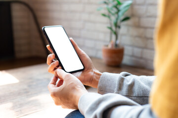 cell phone blank white screen mockup.woman hand holding texting using mobile on desk at...