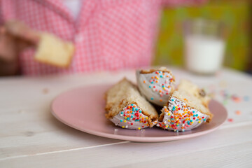 slices of Easter cake on a pink plate on a white wooden table background