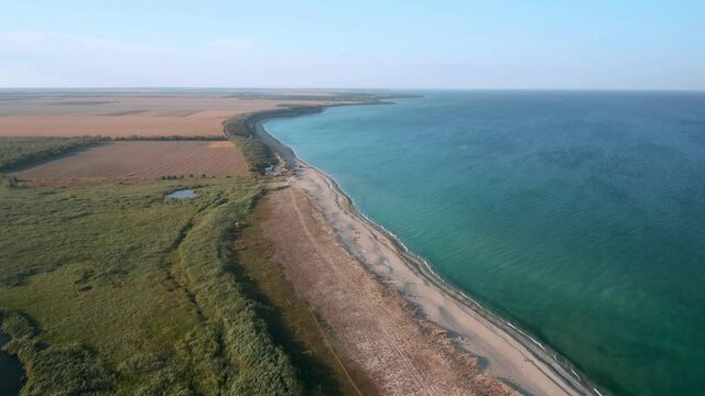 Aerial fly over beautiful empty endless wild beach with sand dunes and lake. A picturesque lagoon - lake Shabla in the north-eastern Bulgaria, which separated from the Black Sea by the sandbar..
